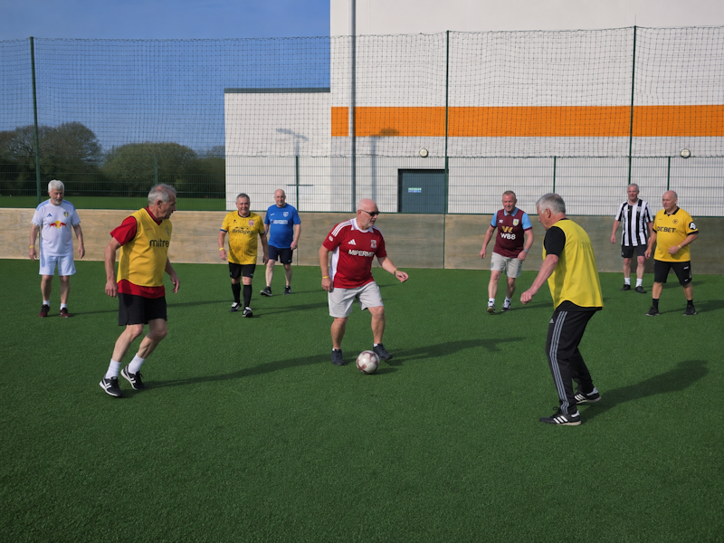 Replace with a landscape action photograph from a normal GWFC training session on the 5G pitch. Show real play and a range of participants. Landscape orientation, 4:3 crop.